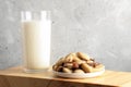 One glass of vegan milk made of brazil nut and nuts in plate on wooden board. Close up. Copy space.