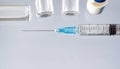 One glass vial of liquid, a vaccine, and a medical syringe close-up on a blue background. concept of vaccination against Royalty Free Stock Photo