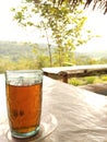 One glass of warm tea during the day with a view of the hills