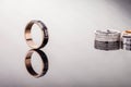 One gold engagement ring with black ceramic and the reflection on a glossy surface and pair of rings in the background Royalty Free Stock Photo