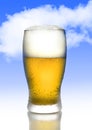 One golden beer with frost and bubbles in full tempting glass with white foam on blue sky Royalty Free Stock Photo