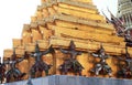 Detail of the golden chedi with the supporting giants around the base, , Wat Phra Kaew, Bangkok, Thailand