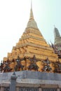 One of the golden chedi with the supporting giants around the base, , Wat Phra Kaew, Bangkok, Thailand Royalty Free Stock Photo