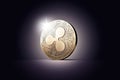 One golden Ripple coin XRP on a gently lit dark background.