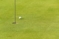 One golf ball near to hole Royalty Free Stock Photo