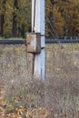 one gray closed metal box with electrical wires on a white concrete pole