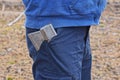 one gray iron ax lies in the waist of blue trousers on the leg of a worker