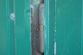One gray iron door hinge on a green metal door Royalty Free Stock Photo
