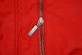 One gray metal open zip on a red fabric Royalty Free Stock Photo