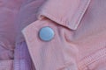 one gray metal rivet button on a pink cotton fabric