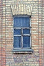 one gray old wooden window with metal bars on the brown brick wall Royalty Free Stock Photo