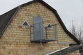 One gray open metal balcony on a brown brick wall of the attic of a private house Royalty Free Stock Photo