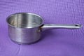 One gray open metal saucepan with a long handle