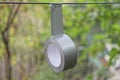 One gray round roll of reinforced tape hanging on a wire