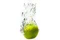 One green apple falling into water on a white background with splashes, drops and bubbles