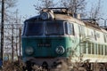 One green or carriage stands on the rails among the trees on a Sunny autumn or spring day. The trees are leafless, but the grass