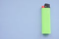 One green lighter on a blue table Royalty Free Stock Photo