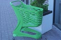 One green plastic empty grocery cart