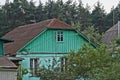 One green wooden attic of a rural house under a gray slate roof Royalty Free Stock Photo