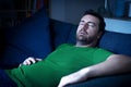 One guy sleeping on the sofa at night watching tv Royalty Free Stock Photo