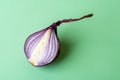 One half of fresh purple onion on a green background. Red ripe onion against green. Organic vegetables and fruits. Veganism and Royalty Free Stock Photo