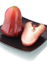 One and a half of red rose apple on black plate Royalty Free Stock Photo