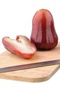 One and a half of red rose apple on chopping board Royalty Free Stock Photo