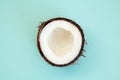 One half of ripe coconut on blue background,top view Royalty Free Stock Photo