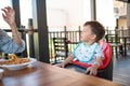 One and half year old baby boy having a meal in the restaurant with his mother Royalty Free Stock Photo