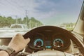 One hand of a driver on steering wheel of a car with speed and raindrops on the windscreen in a rainy day. Royalty Free Stock Photo