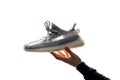 One hand holds a Adidas Yeezy 350 V2 static in its hand.. Released on December 26, 2018