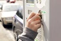 One hand inserting a coin in a parking meter. Royalty Free Stock Photo