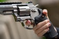 one hand is large silver heavy revolver and aims into the air Royalty Free Stock Photo