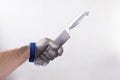 one hand with protective glove, glove of butcher of wire metallic mesh, holding a kitchen knife by the sharp edge, anti cut Royalty Free Stock Photo