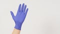 One hand is wearing purple latex gloves on white background Royalty Free Stock Photo