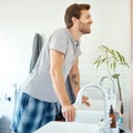 One handsome man checking his teeth in a bathroom at home. Caucasian male cleaning his teeth and looking in a mirror in Royalty Free Stock Photo