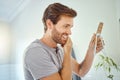 One handsome man checking his teeth in a bathroom at home. Caucasian male cleaning his teeth and looking in a mirror in Royalty Free Stock Photo