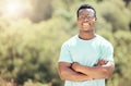 One handsome young african american male wearing glasses and standing outside with his arms folded. Happy and confident Royalty Free Stock Photo