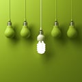 One hanging energy saving light bulb glowing different standing out from unlit incandescent bulbs Royalty Free Stock Photo