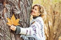 One happy adult woman hug a tree and smile in autumn season outdoor leisure activity. Natural lifestyle and love nature concept Royalty Free Stock Photo