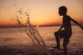 One happy little boy playing on the beach at the sunset time Royalty Free Stock Photo