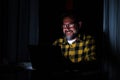 One happy man looking and using laptop at home late night working and watching videos on the computer Royalty Free Stock Photo