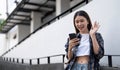 One happy student walking and using smart phone on line in the street at sunset with a warm back light Royalty Free Stock Photo