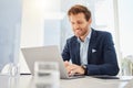 One happy young caucasian businessman working on a laptop in an office. Confident male entrepreneur planning while