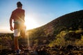 One healthy and fitess man doing exercise and stretching alone looking at the sunset bbetween hills