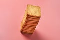 One heap of whole square cookies lies on pink desk on kitchen Royalty Free Stock Photo