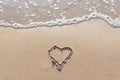 One Heart Drawn in the Sand on a Beach.soft wave of the sea.Romantic love. true love.Beige beach Royalty Free Stock Photo