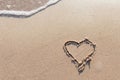 One Heart Drawn in the Sand on a Beach.soft wave of the sea.Romantic love. true love.Beige beach Royalty Free Stock Photo