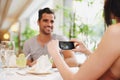 One for her cocktail album. A woman taking a picture while dining out with her partner at a restaurant. Royalty Free Stock Photo