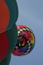 One hot air balloon inflates as another passes overhead